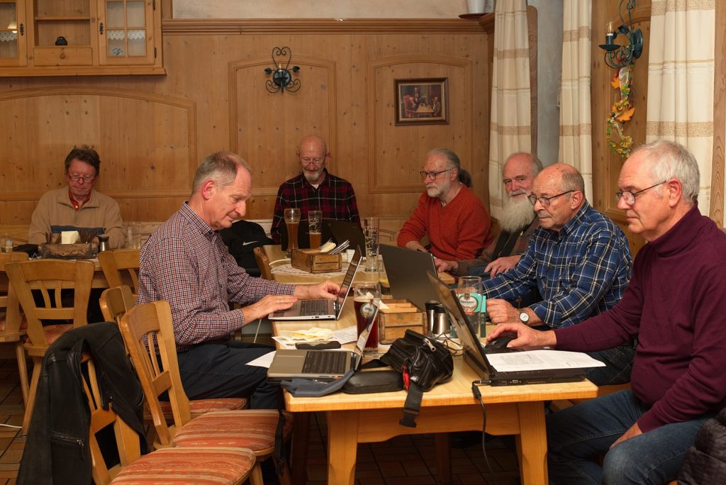 Sieben der Teilnehmer blicken konzentriert auf ihre Notebooks, mit denen sie an der Übungs-Videokonferenz teilnehmen